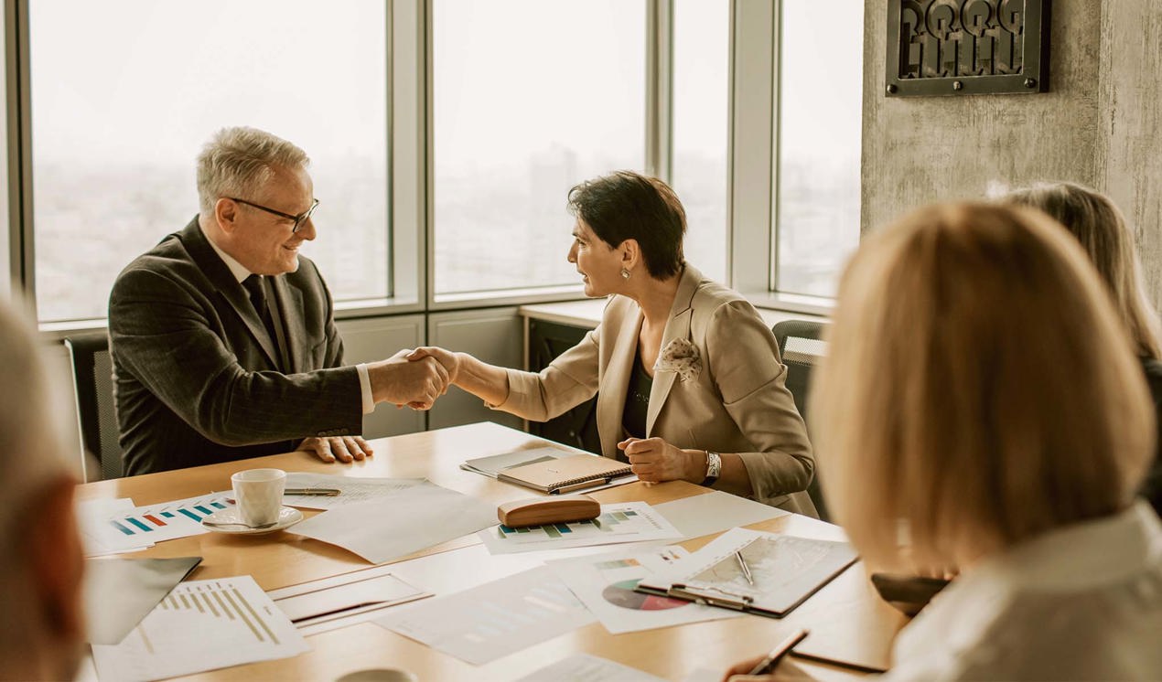 cinclus pharma sitting man and woman shaking hands in conference room